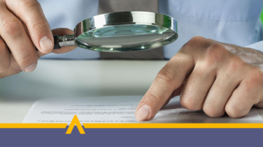 Osoba analizuje treści dokumentu przy użyciu lupy