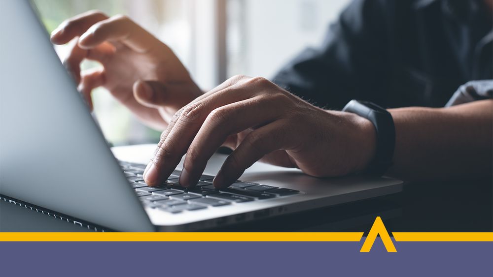 Mężczyzna pracuje przy laptopie, dłonie znajdują się na klawiaturze